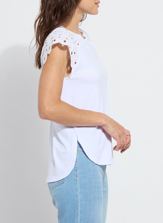 Woman wearing the Lyssé Katarina Eyelet Sleeve Trim Top in white; features embroidered floral eyelet cap sleeves, crew neckline, and a rounded shirttail hem. Lightweight and feminine, available at August Boutique Ripon.