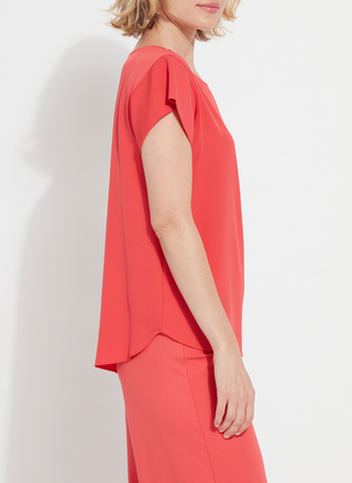 Woman wearing the Melodie Top in Coral Bloom from August Boutique Ripon; features flutter sleeves, scoop neckline, flowy drape, and keyhole back detail. Lightweight and perfect for warm-weather styling.