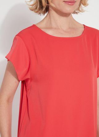 Woman wearing the Melodie Top in Coral Bloom from August Boutique Ripon; features flutter sleeves, scoop neckline, flowy drape, and keyhole back detail. Lightweight and perfect for warm-weather styling.