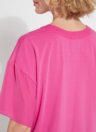 Back view of a woman wearing the Lyssé Cleo Tie Up Top in vibrant hot pink; features dolman short sleeves, v-neckline, and tie-front hem. Styled for comfort and polish, available at August Boutique Ripon.