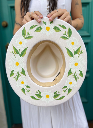 Daisy Flowers hand painted on the bottom of a white brim hat.