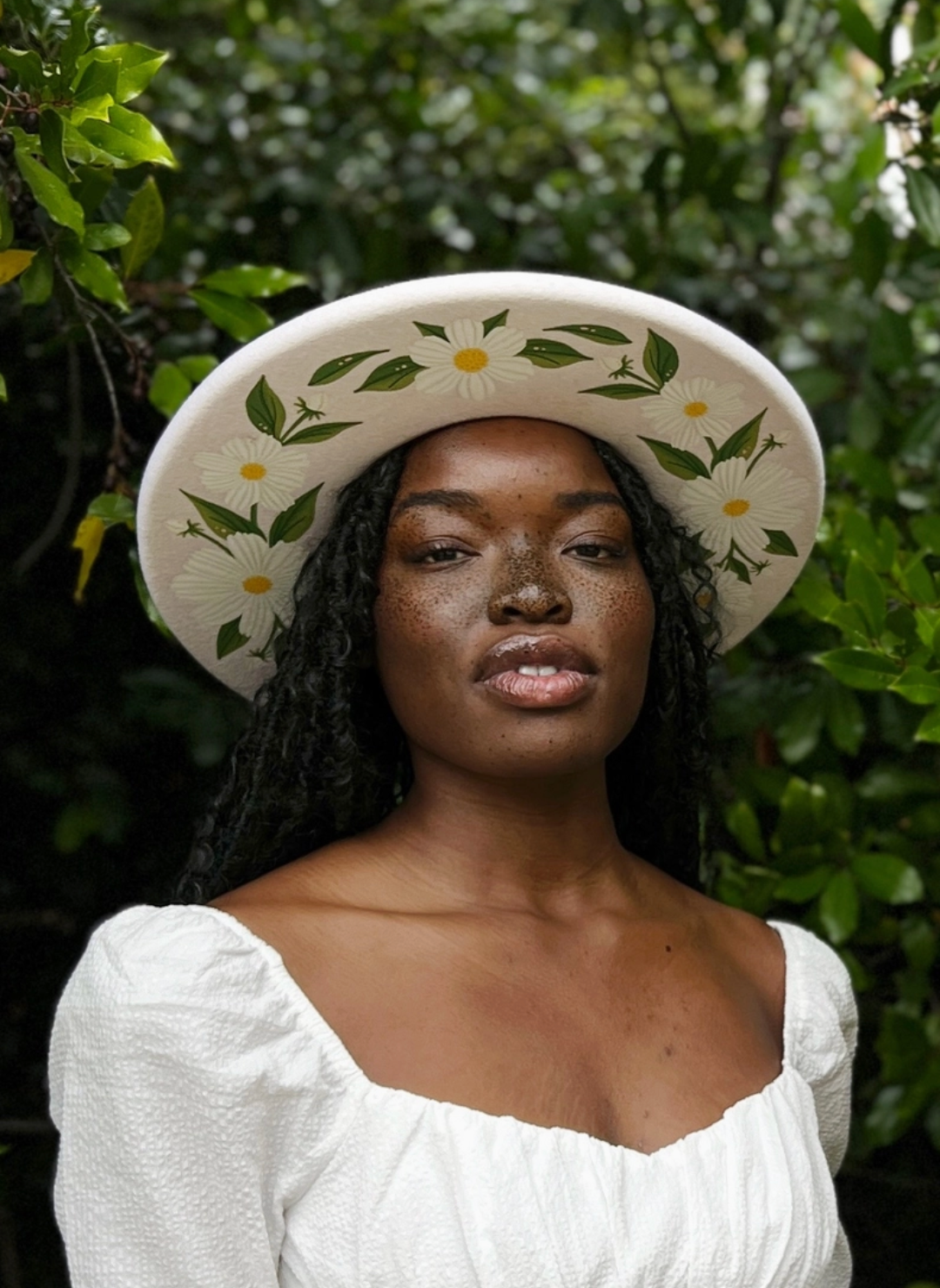 Model wearing Daisy Flowers painted on the bottom of a white brim hat