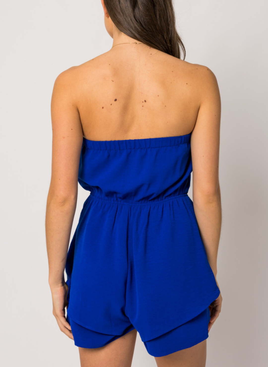 Back view of model wearing blue Pool Party Romper. White background. 