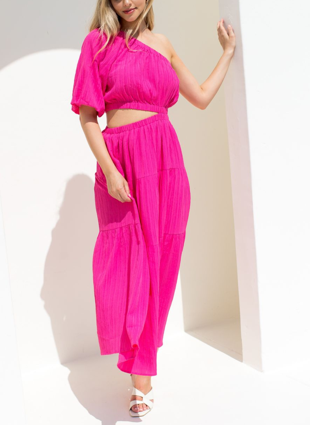 Model wearing fuchsia vibrant Grecian Dream Maxi Dress with one shoulder design and waist cutout detail.