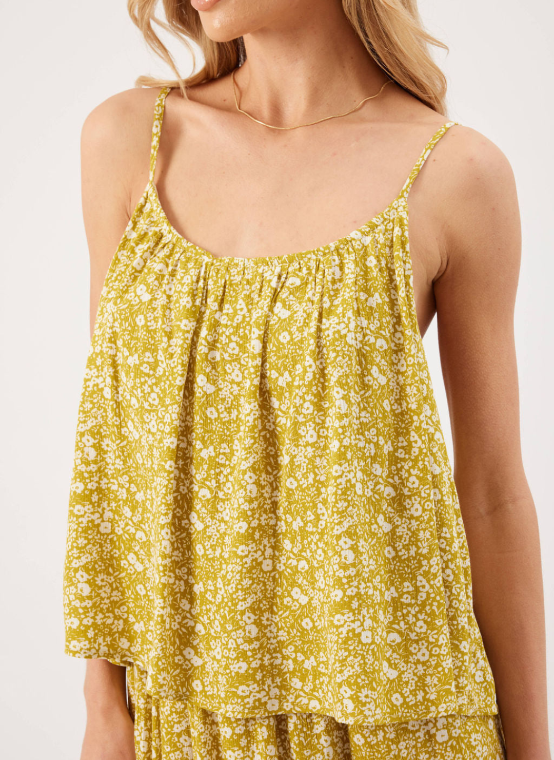 Model wearing Finley Floral Tank with ditsy white floral detailing, curved neckline, and adjustable straps.