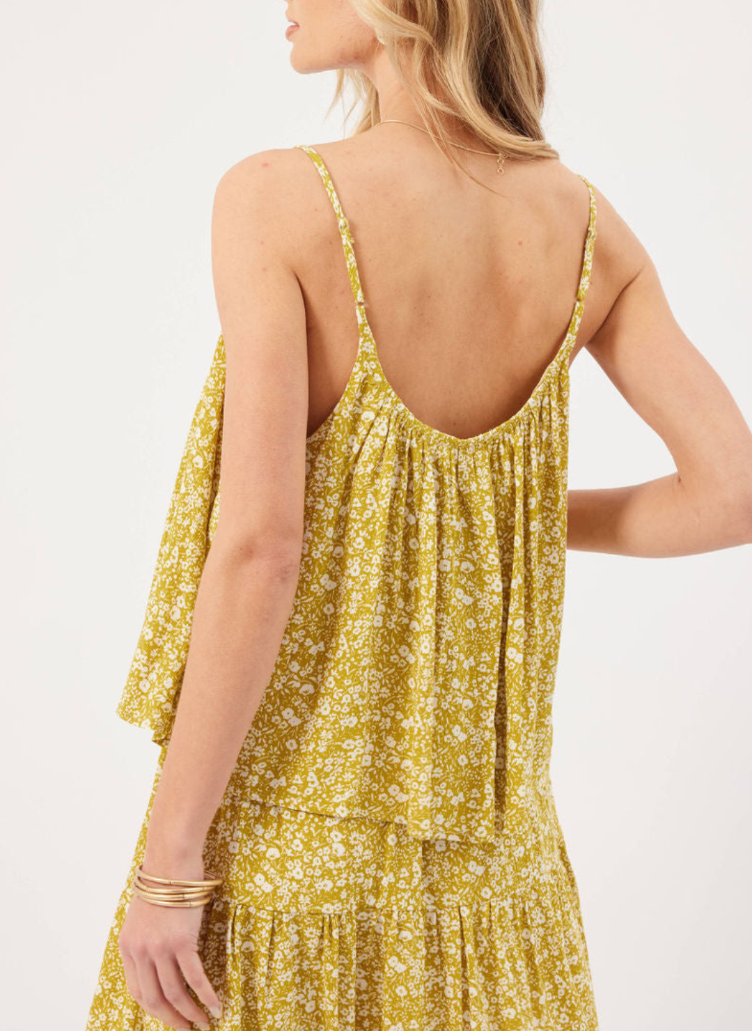 Back view of model wearing Finley Floral Tank with ditsy white floral detailing, curved neckline, and adjustable straps.