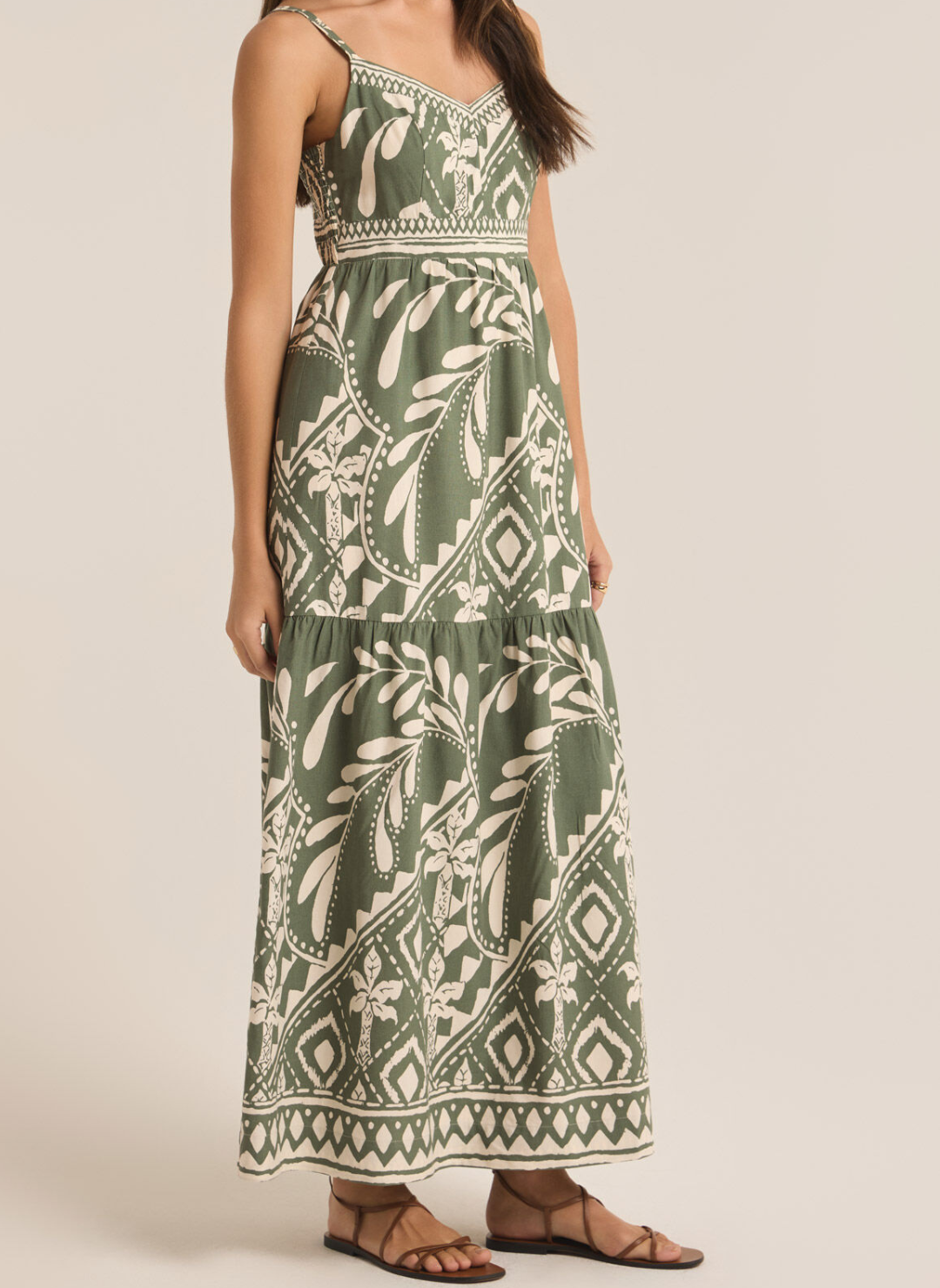 Full body Front/side view of wearing green and white ZS Tazz Midi Dress paired with brown sandals. Models arms are by side. White background. 