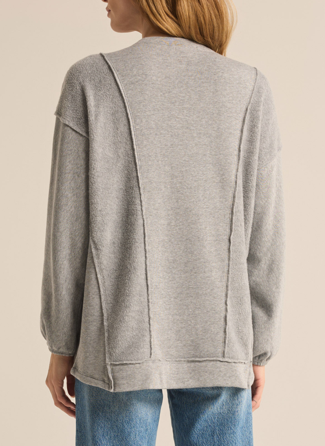 Model is wearing Out of Towner Sweatshirt with denim jeans. Back view of product and white background. 