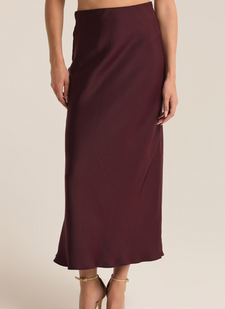 Model is wearing Europa Poly Sheen Skirt with hands by side and facing forward to provide a front view of the skirt. White background.