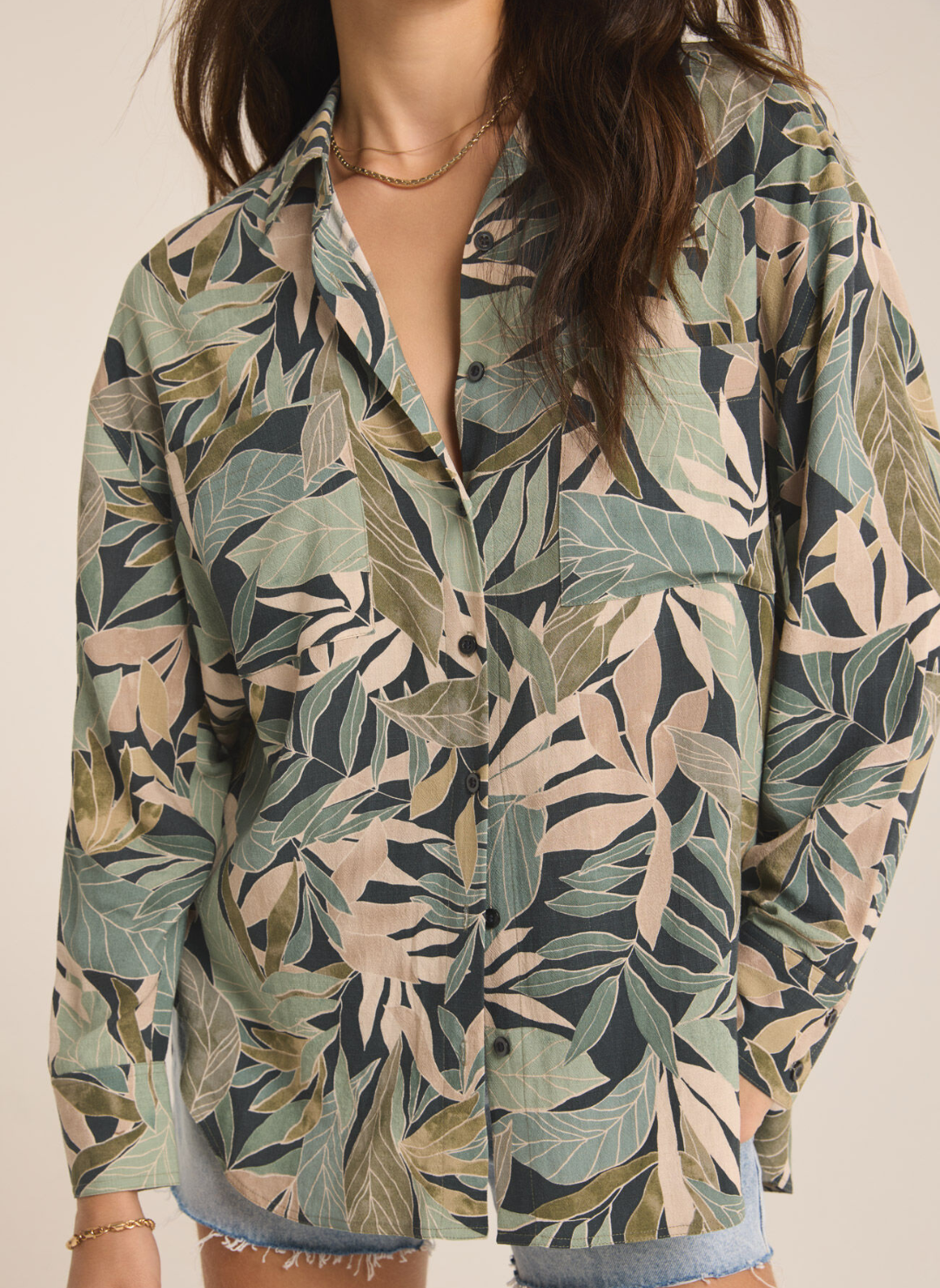 Model wearing Colbie Cusco shirt showing a closer view of the leaves and tropical pattern of the design. Front view.