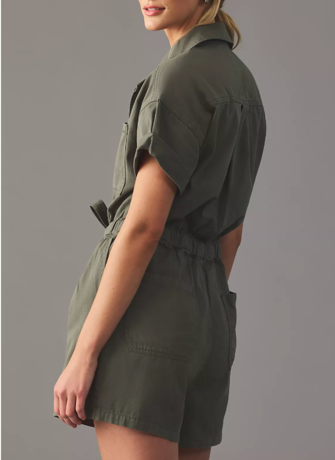 Side/back view of romper. Showing back packets and elastic waistband. 