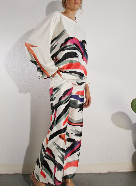 Full body side/front view of Paint Me Pretty Pant with matching top and one hand in pocket.