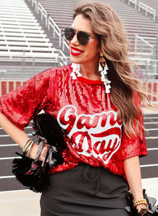 The model is wearing a red game day tee, full of sequins 