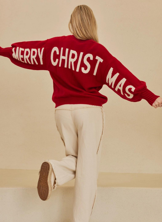 Image shows model with arms out, wearing a red sweater that says Merry Christmas across the back.