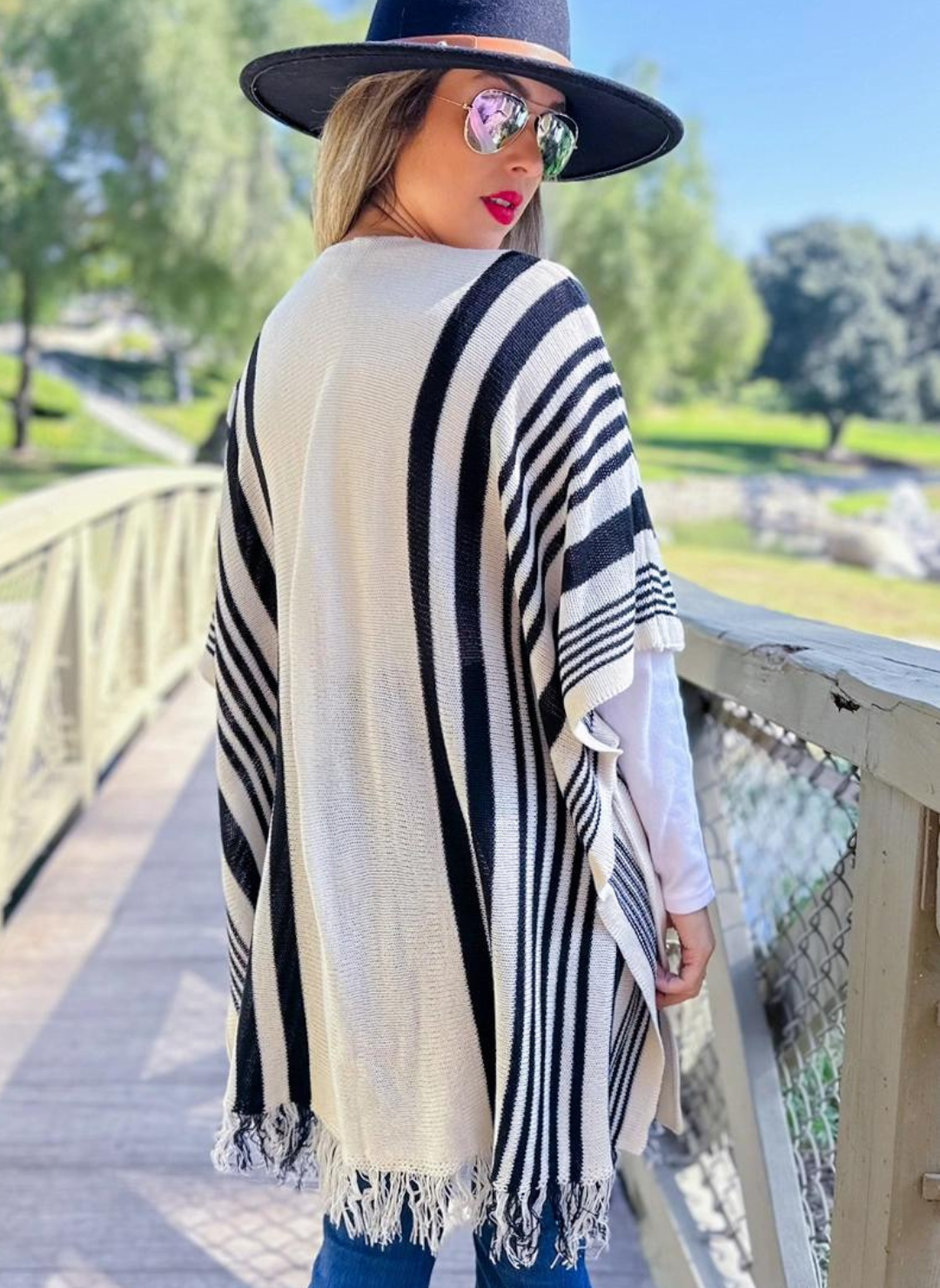 A back profile of the striped cardigan showing the different pattern and length.