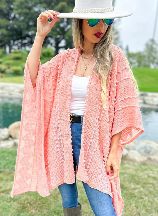 Model is wearing a coral rose 3d textured open front kimono cardigan with a white shirt underneath, black belt, and blue jeans.