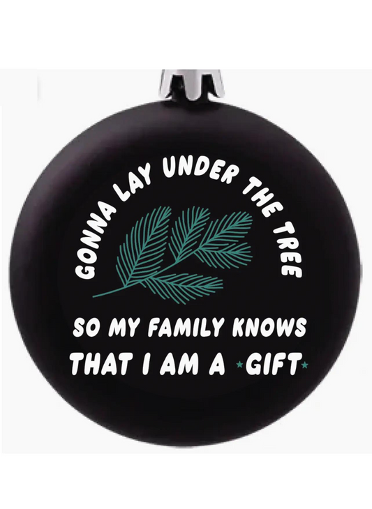 A black Christmas ornament that says “gonna lay under the tree so my family knows that I am a gift”  