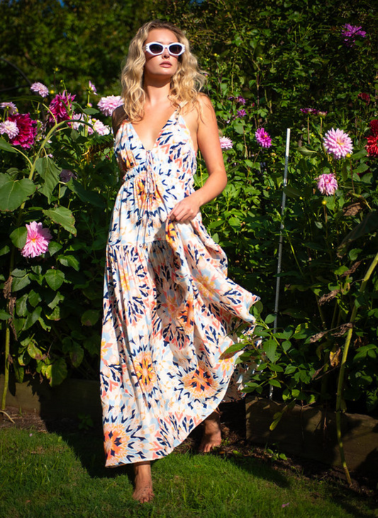 Boho multi-color maxi dress with tie front and smocked waist, adjustable straps, and bold sunset-inspired print – available at August Boutique Ripon.