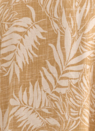 Up close view of cream colored palm leaf pattern on golden palm dress.