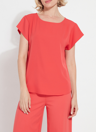 Woman wearing the Melodie Top in Coral Bloom from August Boutique Ripon; features flutter sleeves, scoop neckline, flowy drape, and keyhole back detail. Lightweight and perfect for warm-weather styling.