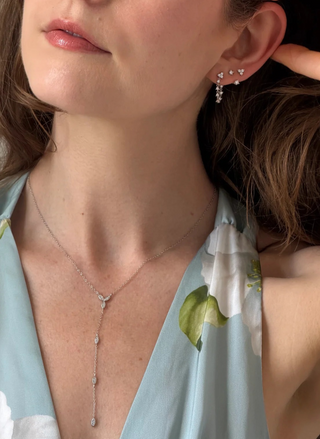 Model wearing the silver FYB Chiara Lariat Necklace with delicate layered chains and a long vertical drop, styled with a light blue outfit