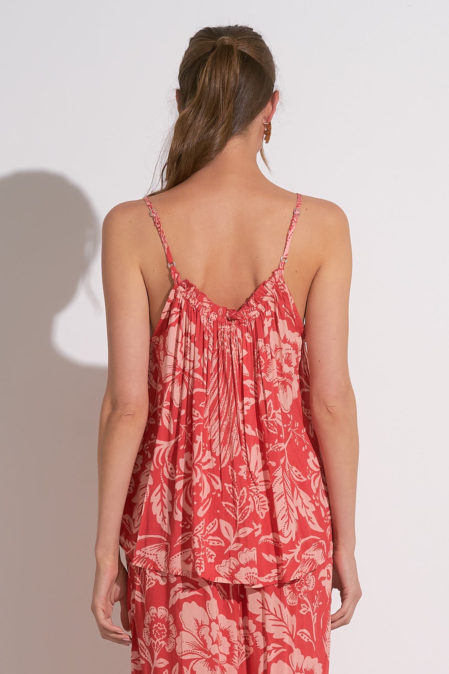 Woman wearing red floral printed smocked tank with adjustable straps, lightweight summer cami top for women, tropical rayon tank from August Boutique.