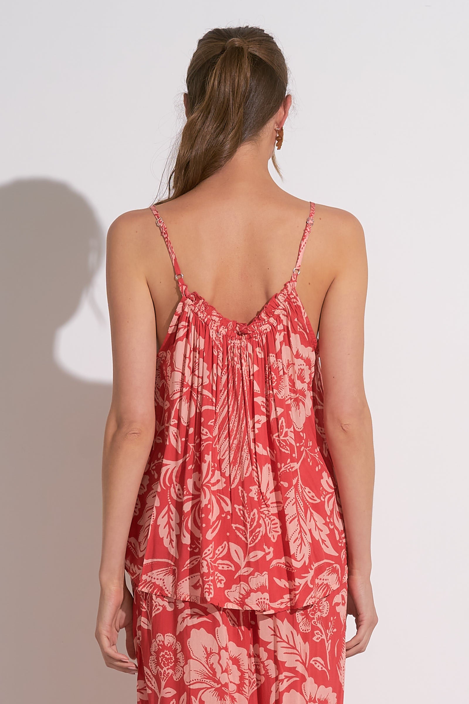 Woman wearing red floral printed smocked tank with adjustable straps, lightweight summer cami top for women, tropical rayon tank from August Boutique.